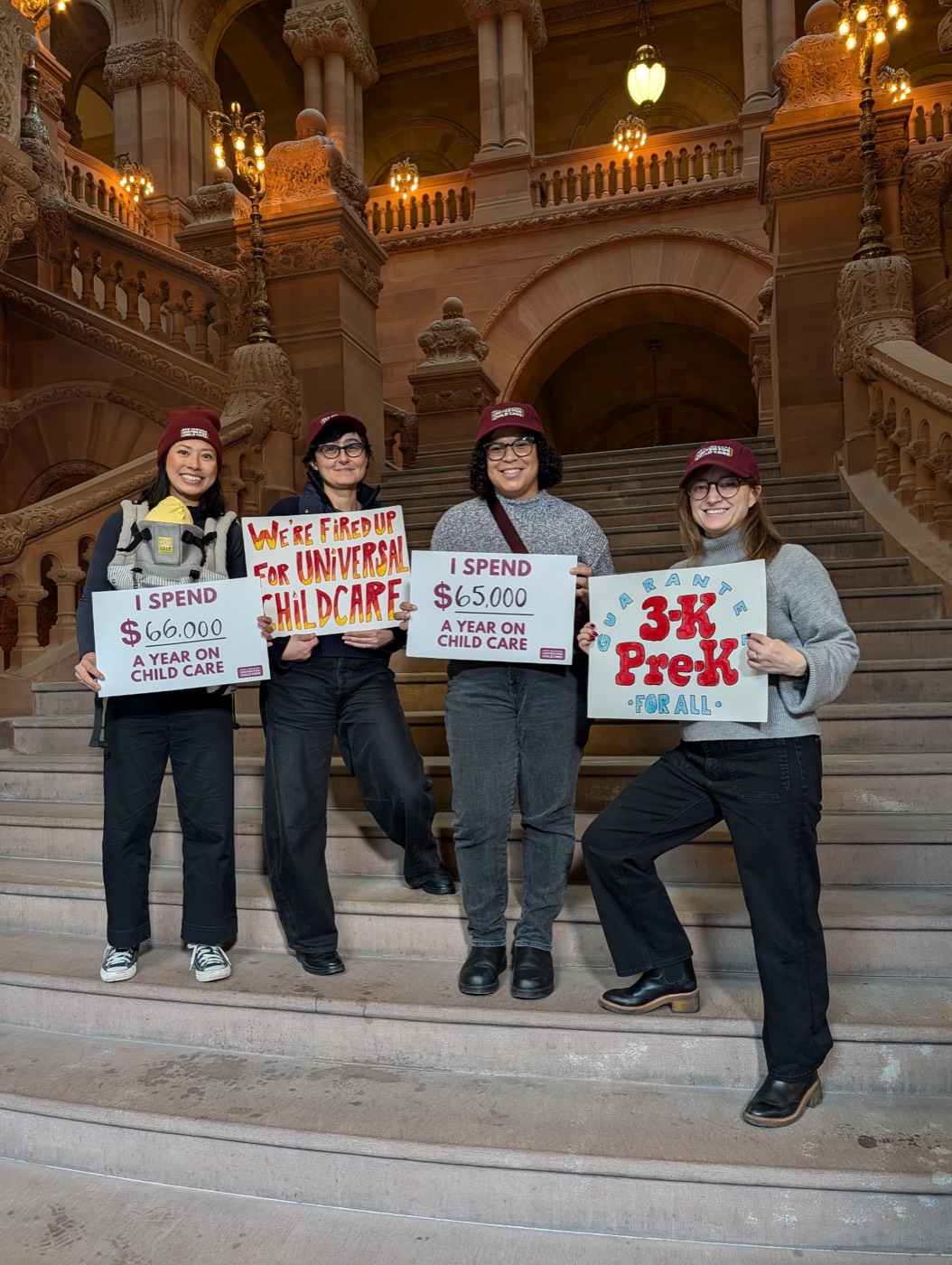 Advocates hold “3-K & Pre-K for all” signs on the New York State Capitol steps in Albany.