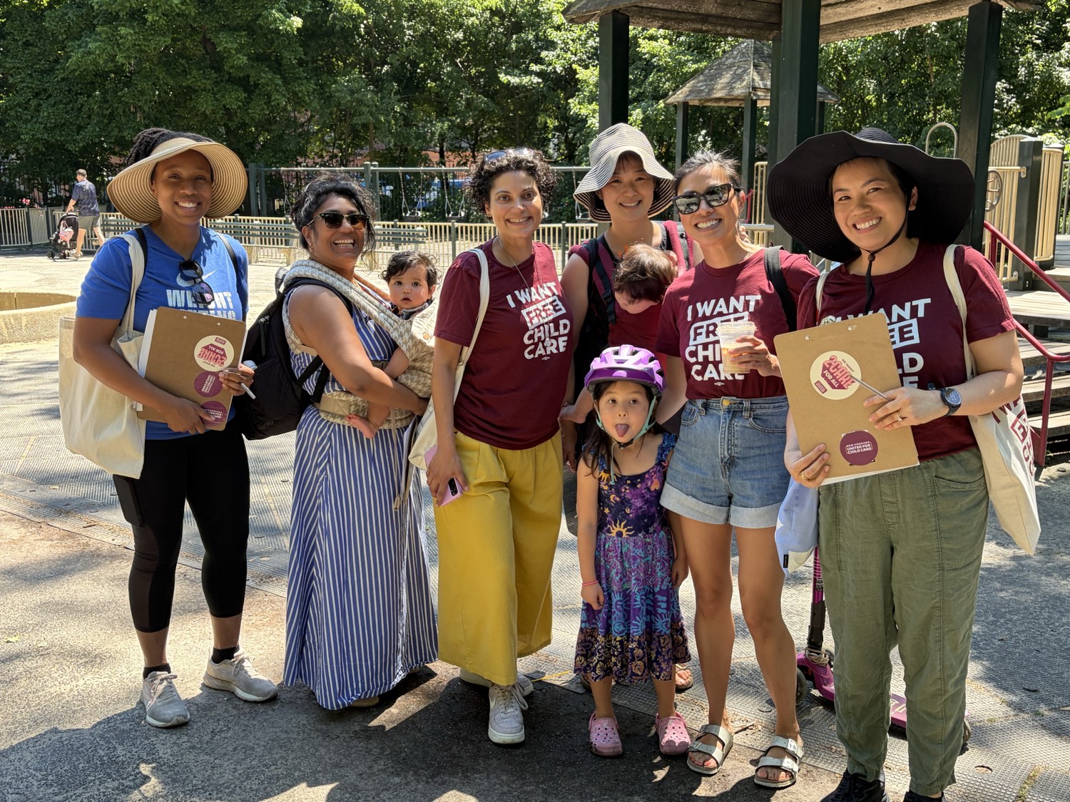 Parents with “I want free child care” tote bags gather at a New Yorkers United for Child Care park event.