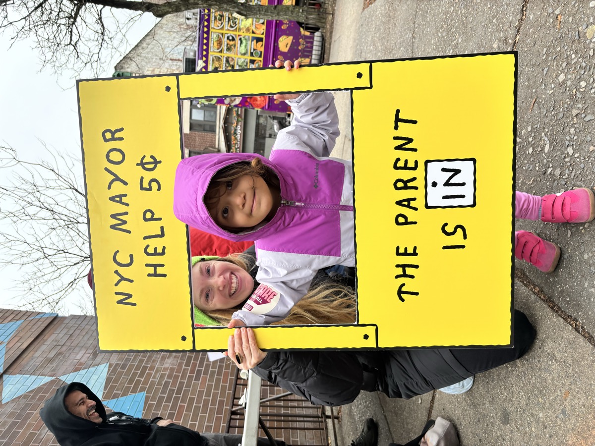 A parent and child at a New Yorkers United for Child Care street event.